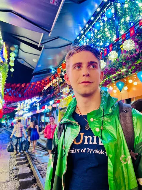 Richard Roos Jyväskylän yliopiston paidassa värivaloin koristellulla katukujalla.